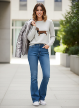 Kaschmirpullover Dackel mit Flared Jeans und Metallic-Jacke über Schulter